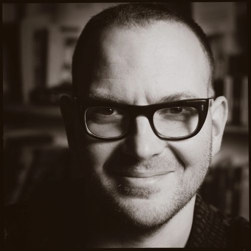 A black and white headshot of author, journalist and activist Cory Doctorow