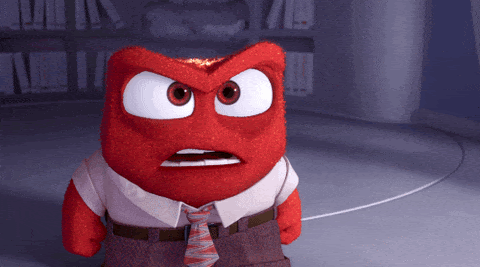 A GIF of a cartoon character with a square head, red skin and coals on the top of their head, dressed in a suit, yelling: "What."